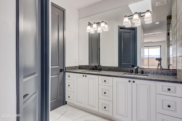 bathroom with marble finish floor, visible vents, a sink, and double vanity