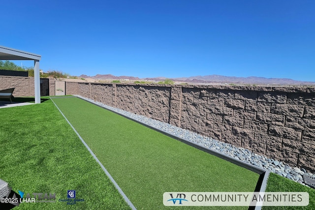 view of yard featuring fence and a mountain view