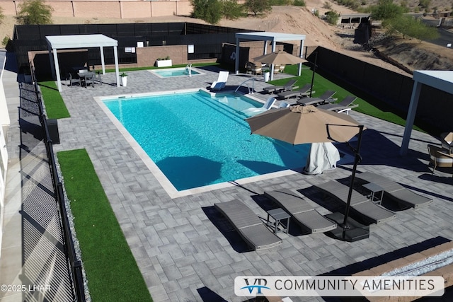 pool featuring a community hot tub, fence, and a patio