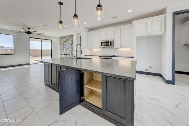 kitchen featuring decorative backsplash, appliances with stainless steel finishes, marble finish floor, open shelves, and a sink