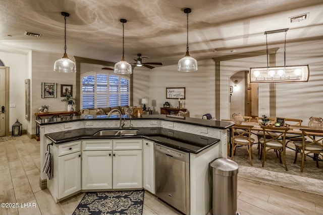 kitchen with hanging light fixtures, dishwasher, sink, and white cabinets