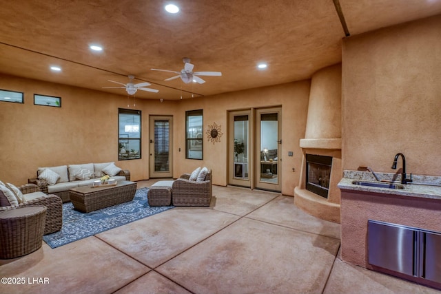 view of patio / terrace with an outdoor living space, sink, and ceiling fan