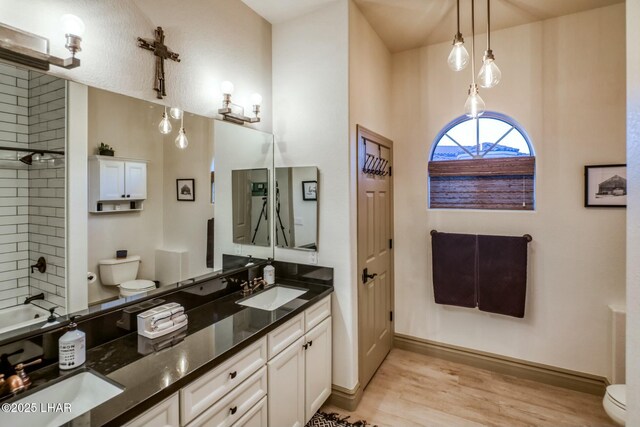 full bathroom with vanity, toilet, shower / bath combination, and hardwood / wood-style floors