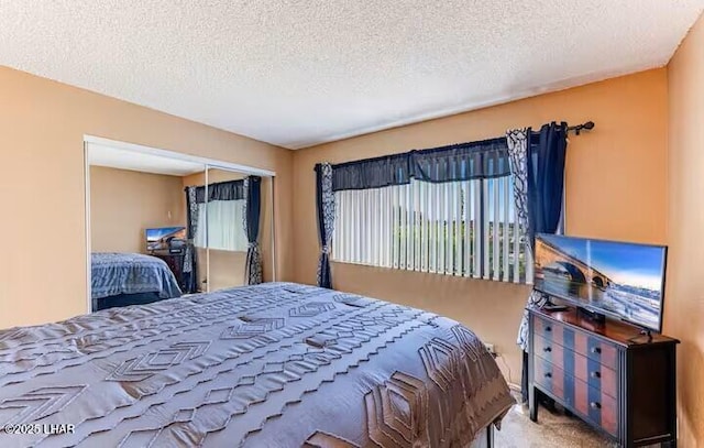 bedroom featuring carpet floors, a textured ceiling, and a closet