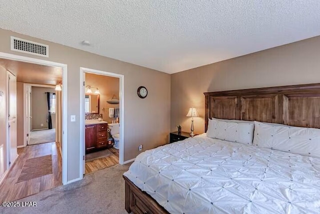 bedroom with a textured ceiling and light colored carpet