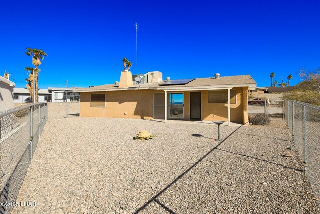 back of house featuring a patio and solar panels