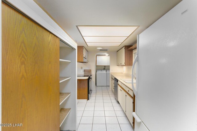 kitchen with light tile patterned floors, washing machine and dryer, black range with electric cooktop, stainless steel dishwasher, and white fridge