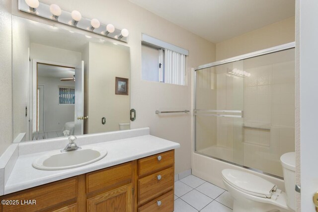 full bathroom featuring enclosed tub / shower combo, vanity, toilet, and tile patterned flooring