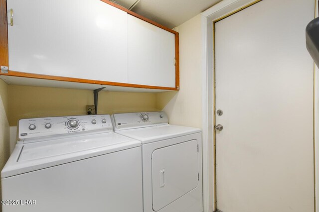 washroom featuring cabinets and washer and dryer