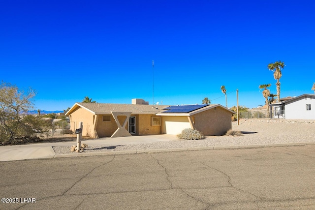 single story home featuring a garage and solar panels