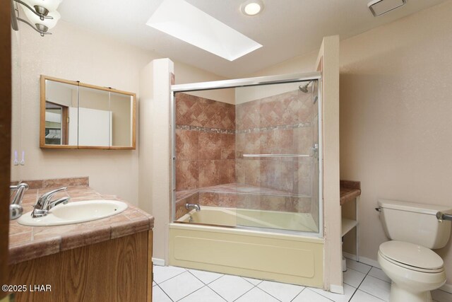 full bathroom featuring bath / shower combo with glass door, a skylight, tile patterned flooring, vanity, and toilet