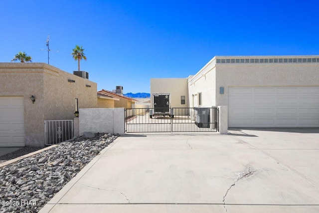 view of home's exterior with a gate, driveway, fence, and stucco siding