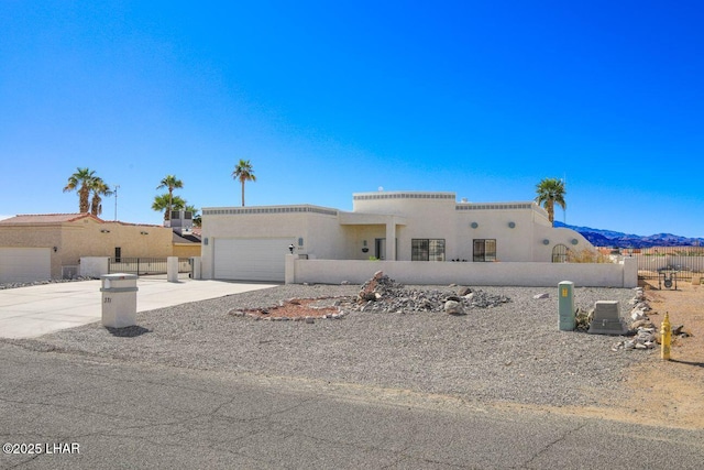 view of front of home with stucco siding, a garage, concrete driveway, and fence