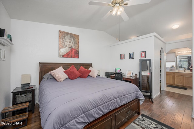 bedroom featuring lofted ceiling, connected bathroom, sink, dark hardwood / wood-style flooring, and ceiling fan