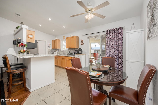 dining space featuring lofted ceiling, ceiling fan, and light tile patterned flooring