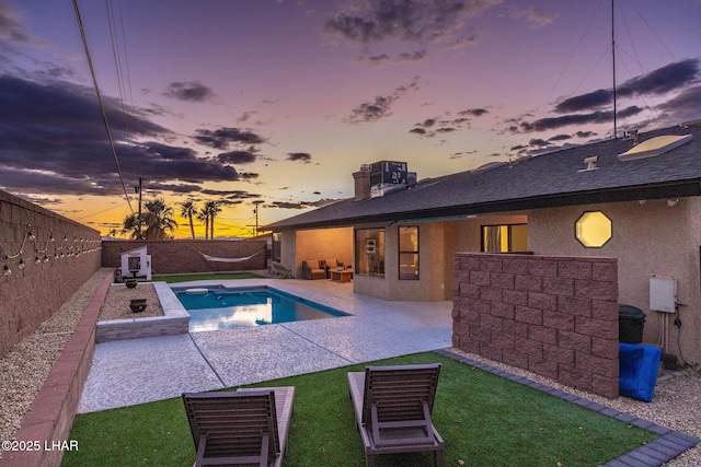 pool at dusk with a patio, central AC unit, and a fenced backyard