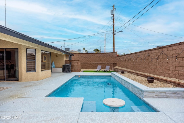 view of swimming pool with a fenced backyard, a fenced in pool, and a patio