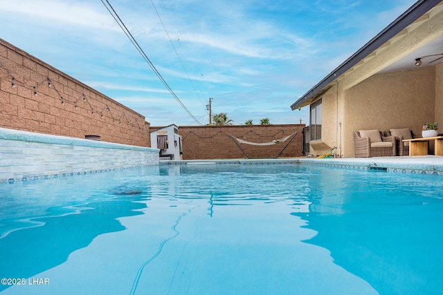 view of swimming pool with fence, outdoor lounge area, and a fenced in pool