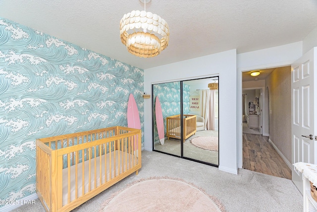 bedroom featuring a closet, baseboards, a textured ceiling, and carpet flooring