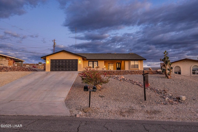 view of front of house featuring concrete driveway, fence, an attached garage, and stucco siding