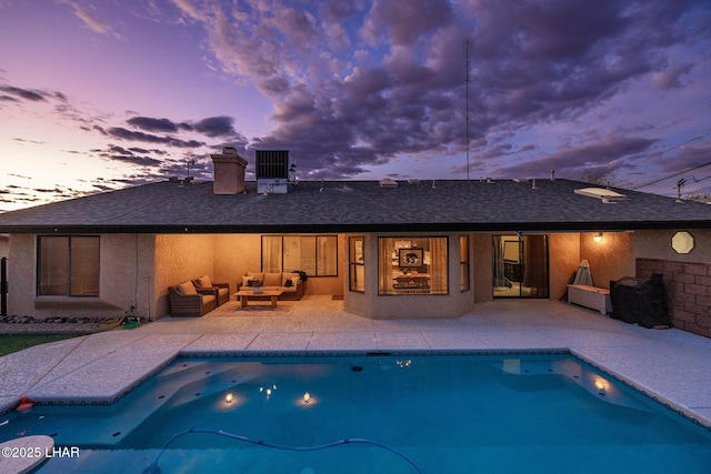 pool at dusk with a patio area, outdoor lounge area, and an outdoor pool