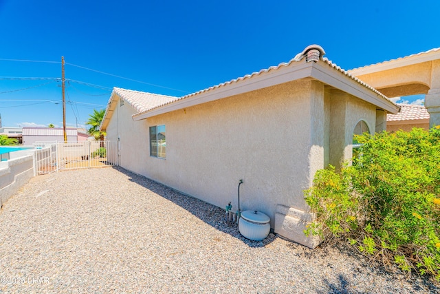 2335 Palo Verde Blvd N, Lake Havasu City, AZ 86404 - view of home's exterior with a gate, stucco siding, fence, and a tiled roof
