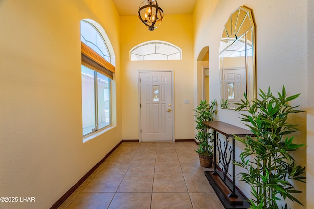 2335 Palo Verde Blvd N, Lake Havasu City, AZ 86404 - entryway with tile patterned floors, arched walkways, a chandelier, baseboards, and a high ceiling