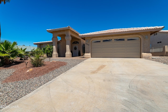 2335 Palo Verde Blvd N, Lake Havasu City, AZ 86404 - mediterranean / spanish-style house featuring concrete driveway, a tile roof, stucco siding, and a garage