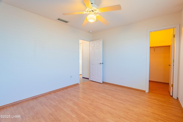 2335 Palo Verde Blvd N, Lake Havasu City, AZ 86404 - unfurnished bedroom featuring light wood finished floors, a spacious closet, baseboards, a closet, and ceiling fan