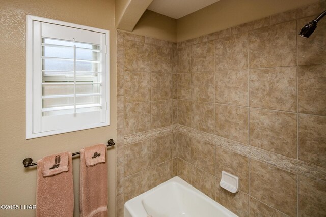 bathroom featuring tiled shower / bath