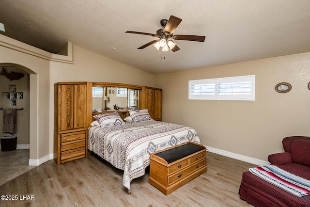 bedroom with ceiling fan, lofted ceiling, and wood-type flooring