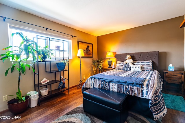 bedroom with wood finished floors and baseboards