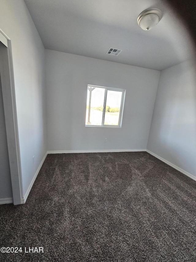 empty room with dark colored carpet