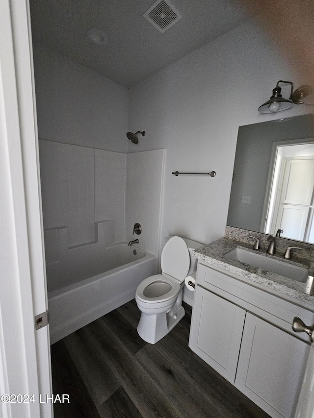 full bathroom featuring washtub / shower combination, vanity, toilet, and hardwood / wood-style floors