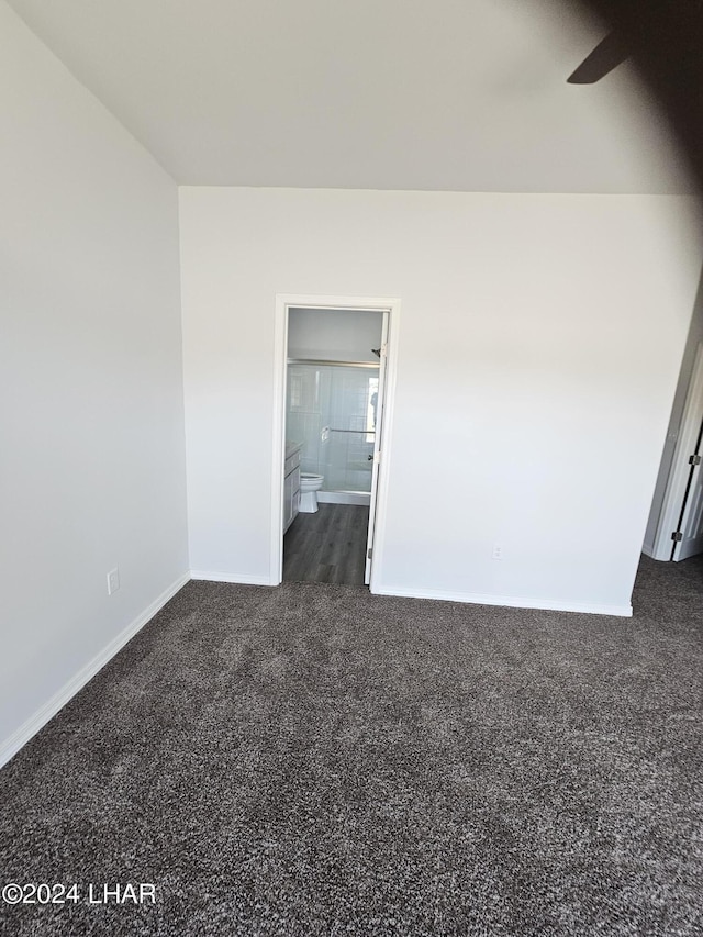 unfurnished room featuring dark carpet