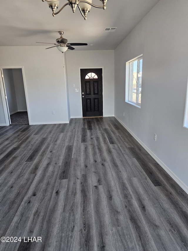 foyer with ceiling fan with notable chandelier and dark wood-type flooring