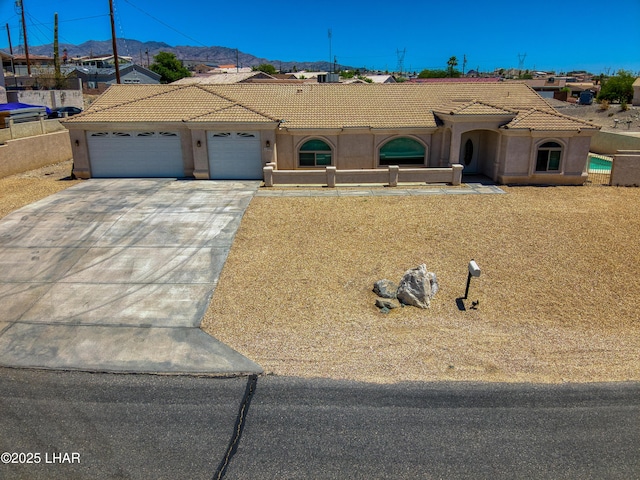 3000 Mirage Dr, Lake Havasu City, AZ 86404 - mediterranean / spanish-style house featuring an attached garage, a mountain view, driveway, stucco siding, and a tiled roof