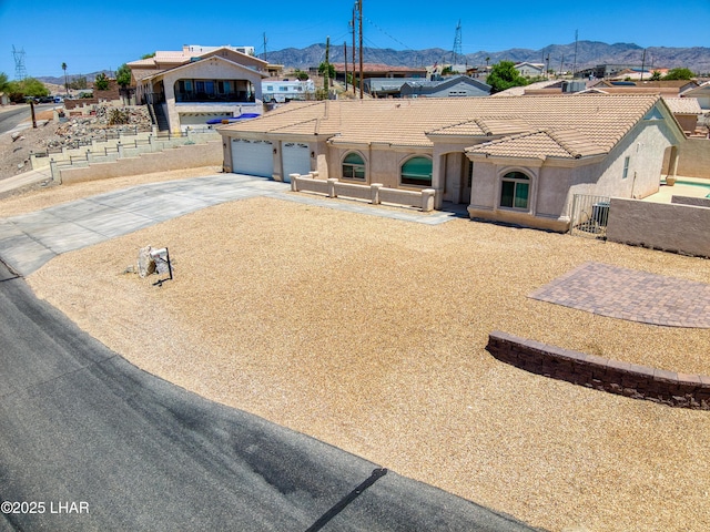 3000 Mirage Dr, Lake Havasu City, AZ 86404 - view of front facade featuring concrete driveway, a mountain view, stucco siding, an attached garage, and a tiled roof