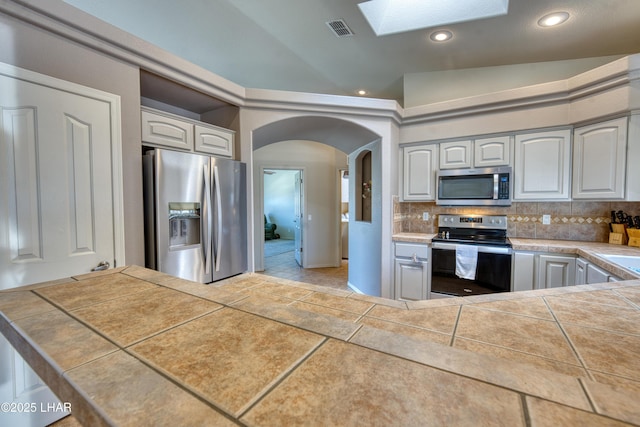 3000 Mirage Dr, Lake Havasu City, AZ 86404 - kitchen with appliances with stainless steel finishes, a skylight, backsplash, light tile patterned floors, and recessed lighting