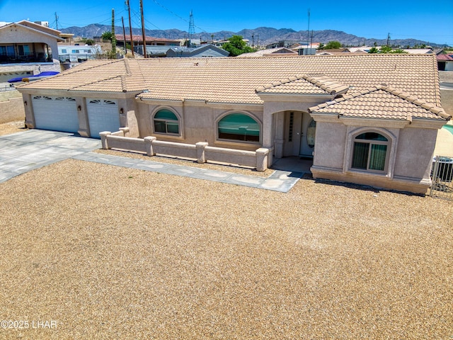 3000 Mirage Dr, Lake Havasu City, AZ 86404 - mediterranean / spanish-style house with a tile roof, driveway, stucco siding, a mountain view, and an attached garage