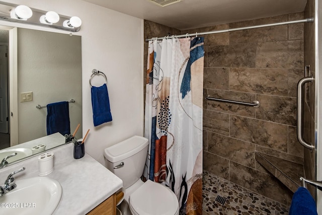 bathroom with visible vents, vanity, a shower stall, and toilet