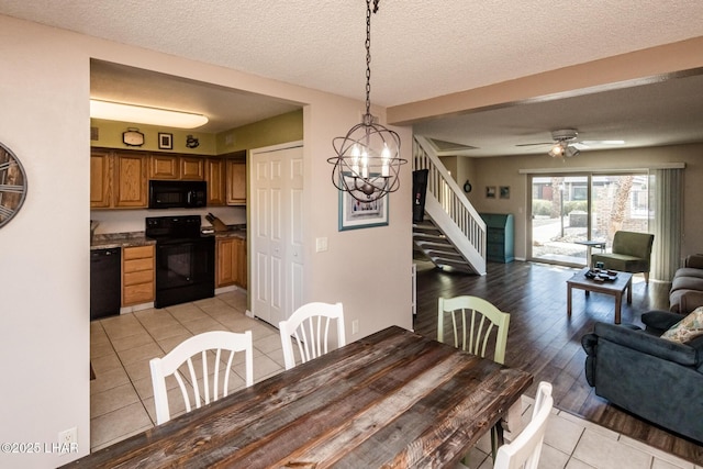 dining space featuring light tile patterned floors, a textured ceiling, stairs, and ceiling fan with notable chandelier