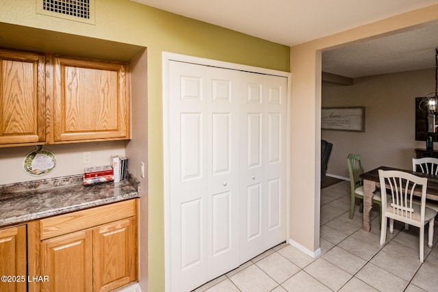 kitchen with light tile patterned floors, visible vents, and baseboards