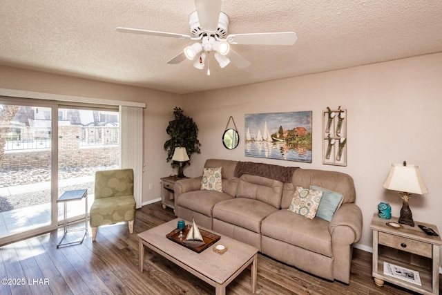 living area with baseboards, a textured ceiling, a ceiling fan, and wood finished floors