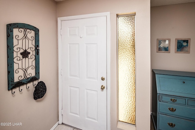 doorway featuring baseboards