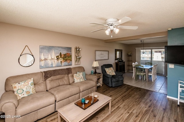 living area featuring a textured ceiling, a ceiling fan, and wood finished floors