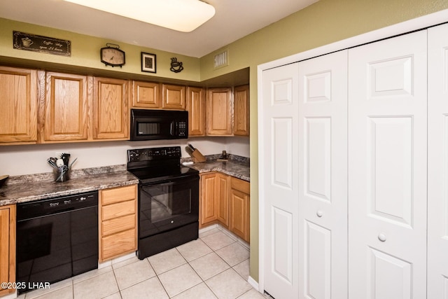 kitchen with black appliances, light tile patterned floors, dark countertops, and visible vents