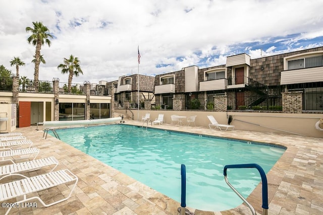 community pool featuring a patio and fence