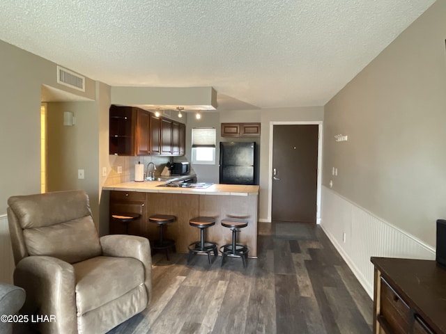 276 Lake Havasu Ave S Unit C19, Lake Havasu City, AZ 86403 - kitchen with a breakfast bar, a peninsula, dark wood finished floors, freestanding refrigerator, and wainscoting