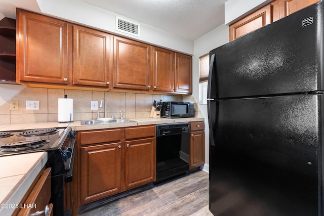 276 Lake Havasu Ave S Unit C19, Lake Havasu City, AZ 86403 - kitchen featuring visible vents, brown cabinets, black appliances, and a sink